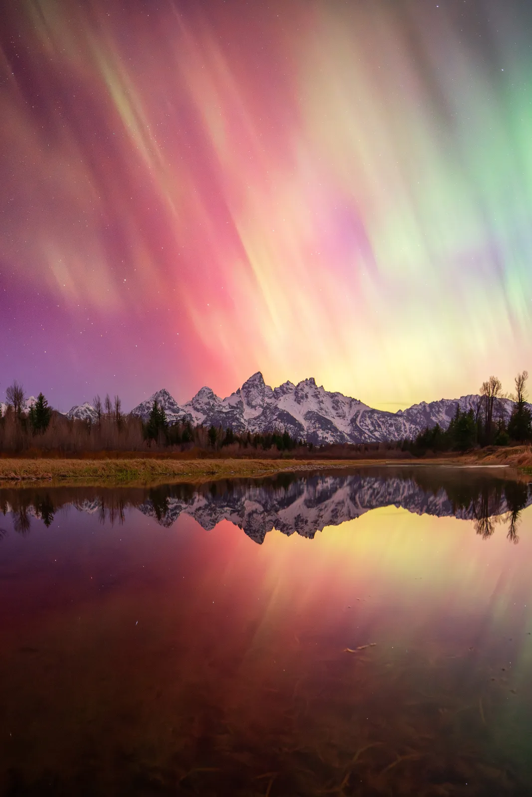 Reflection of the Grand Teton Range and the aurora borealis.