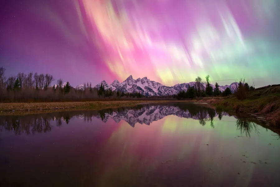 The aurora borealis makes an appearance over the Grand Teton National Park during a night photography workshop.