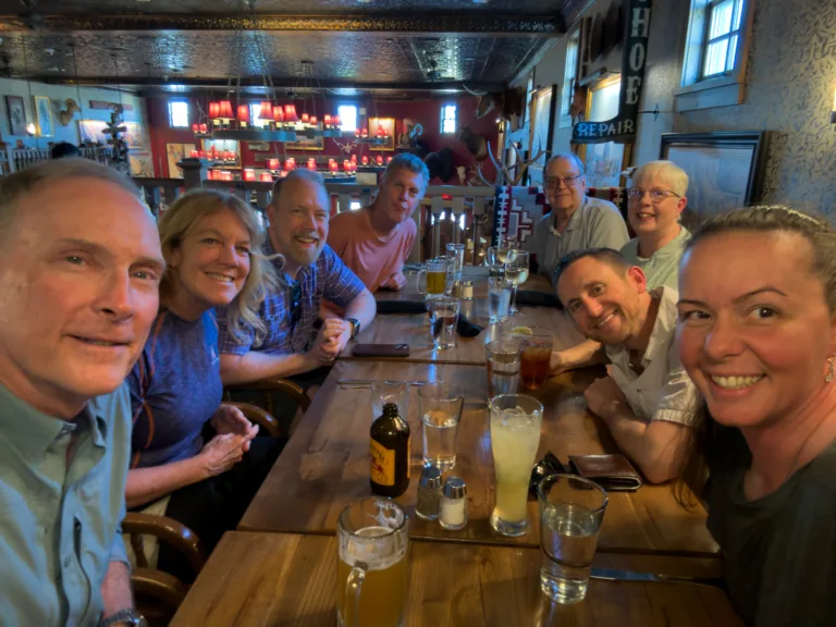 Brad Goldpaint and Evie Wilder pose with their night photography workshop participants during the group dinner.