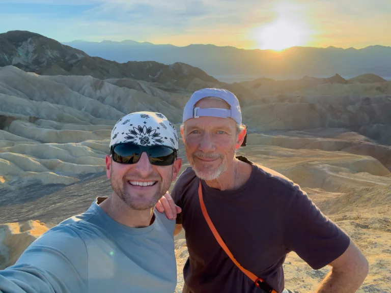 Brad Goldpaint and Bill at Zabriskie Point during a Death Valley night photography workshop as the sun sets over the Panamint Range.